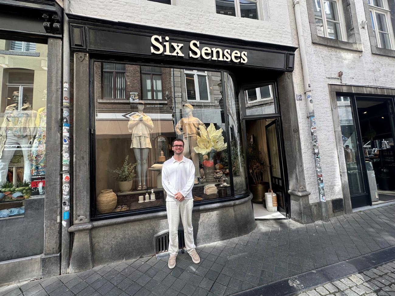 afbeelding van persoon in witte kleren voor een winkel