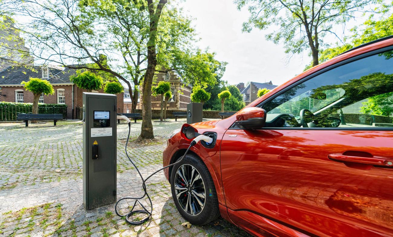 Rode elektrische auto aan een oplaadpaal