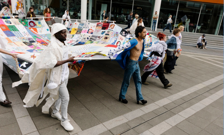 Groep textielkunstenaars die hun kunstwerk tonen