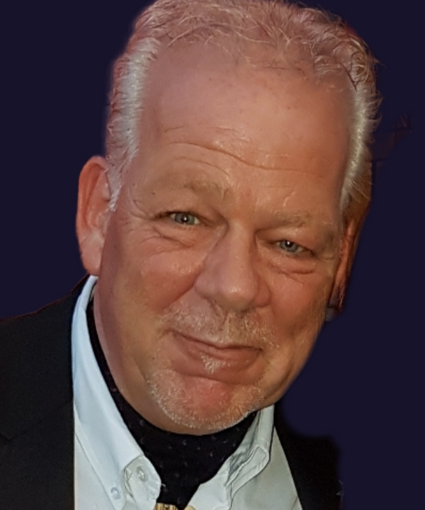 Een gezicht van een man met een wit hemd en een zwarte jas met grijswit haar
