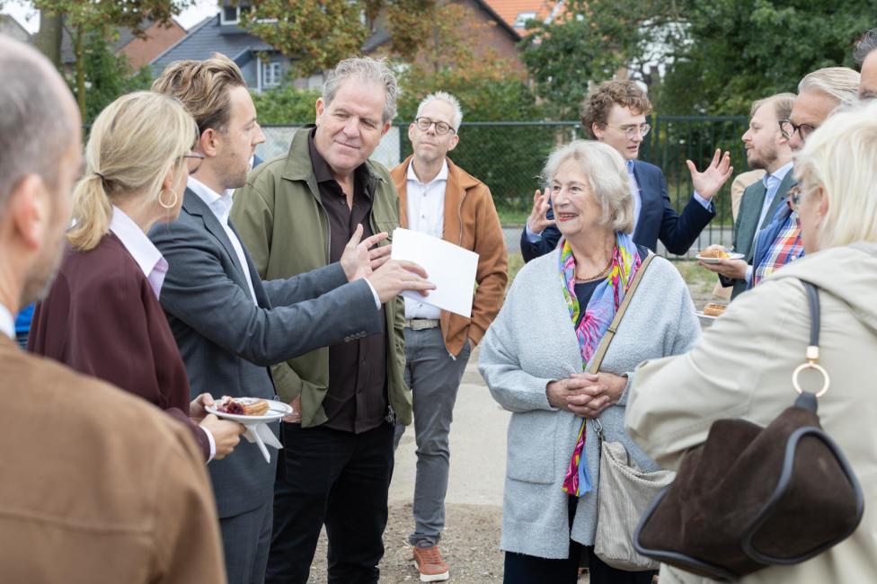 Groep mensen in gesprek tijdens een werkbezoek aan de Spoorzone Maastricht.