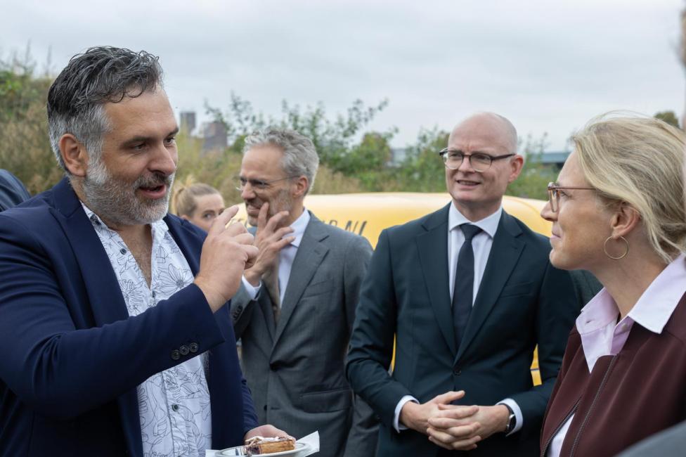 Vier mensen praten met elkaar tijdens een werkbezoek aan de Spoorzone Maastricht.